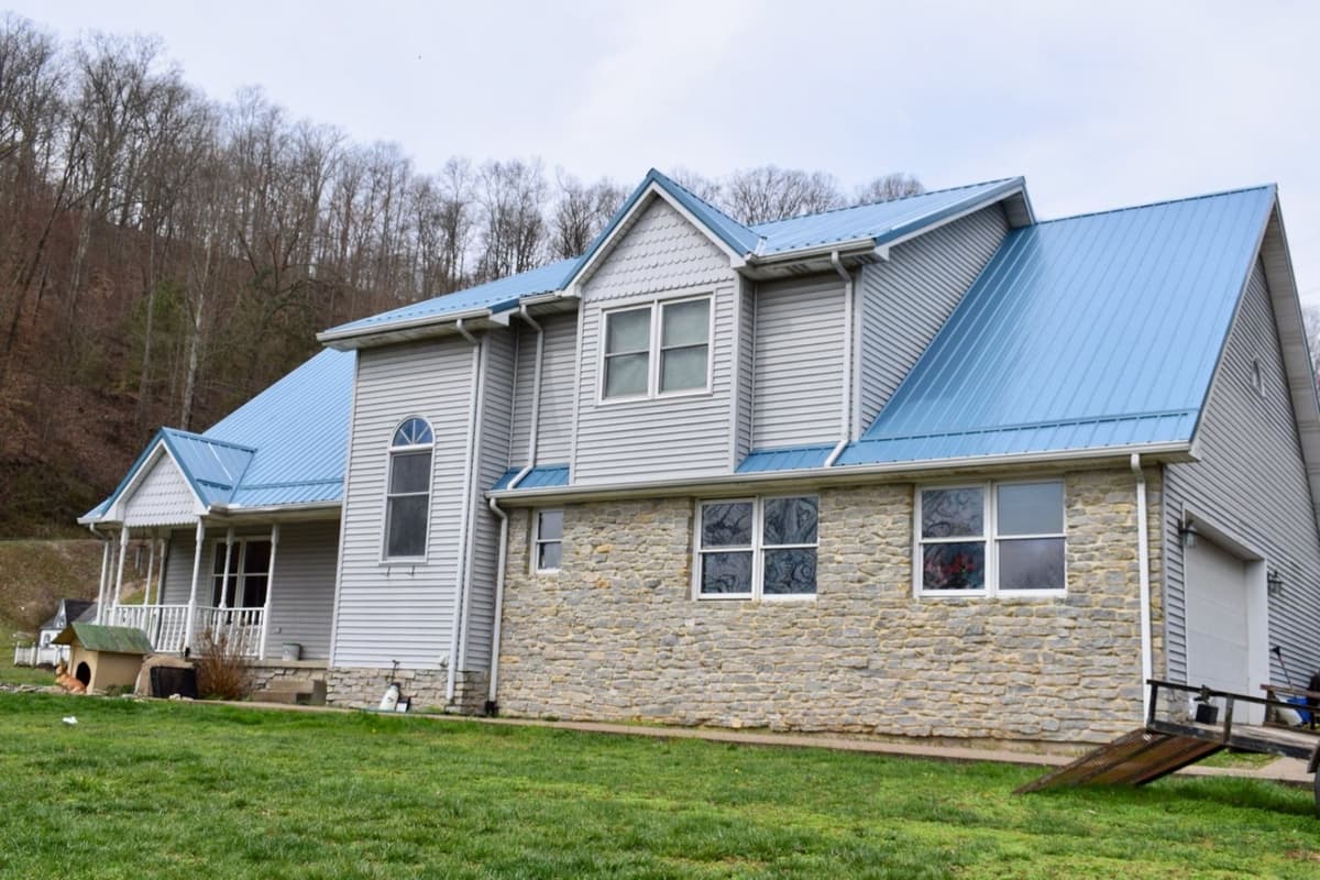 Stone home with blue metal roof